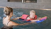 Mutter und Kind schwimmen gemeinsam im Pool des Familienhotels Gorfion