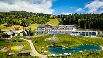 Luftaufnahme im Sommer vom Familienhotel Familien Resort Petschnighof in Kärnten.
