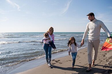 Eine Familie genißt die Zeit am Strand des Familienhotels strandkind an der Ostsee.