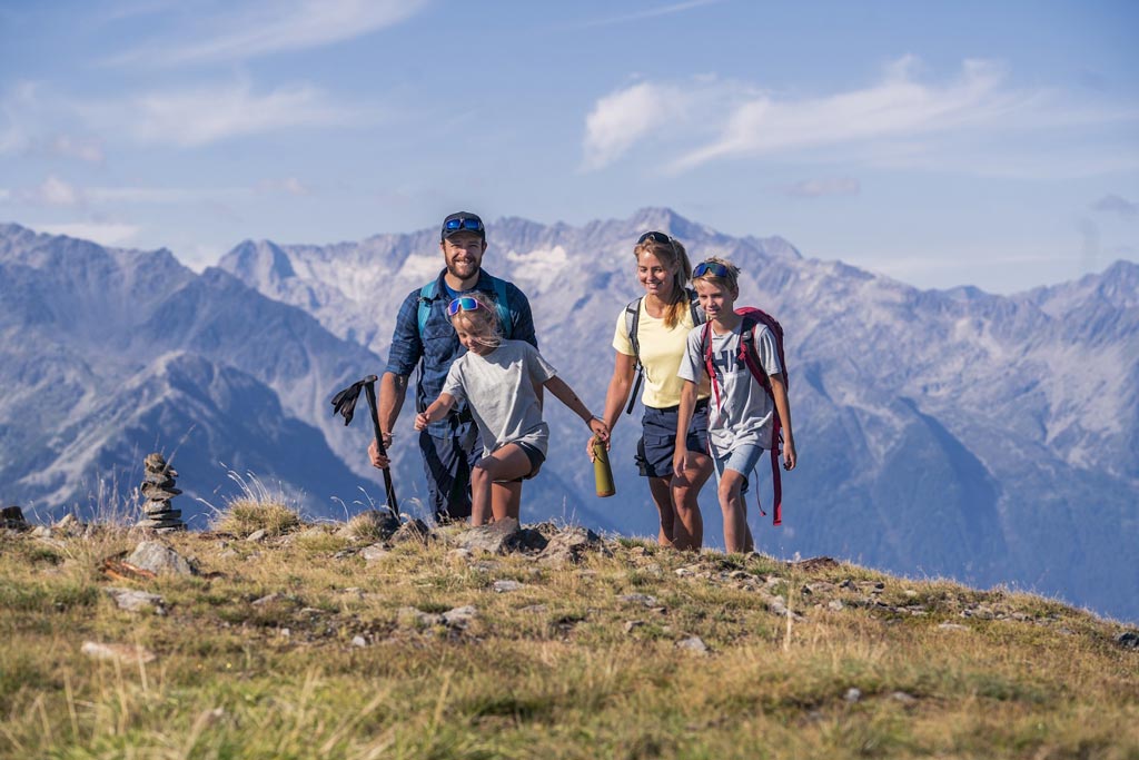 Eine Familien die in den Bergen Wandern geht.