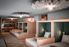 Moderner Ruhebereich im Familienhotel Alpenhof Dolomit Family mit gemütlichen Liegen und stimmungsvoller Beleuchtung für erholsame Wellnessmomente.