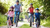 Familie macht einen Ausflug mit dem Fahrrad im Familienurlaub an der Nordsee