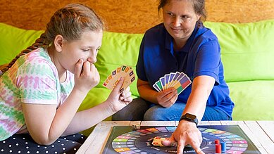 Mutter und Tochter spielen ein Brettspiel im Family Club Harz