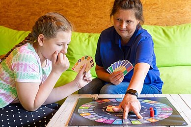 Mutter und Tochter spielen ein Brettspiel im Family Club Harz