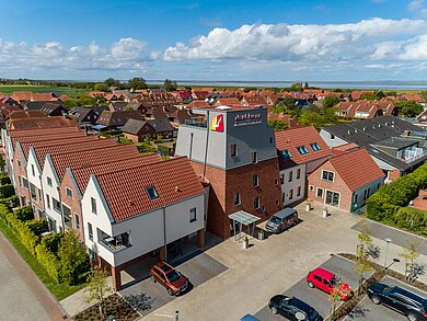 Ansicht aus der Vogelperspektive auf das Familienhotel Deichkrone an der Nordsee.