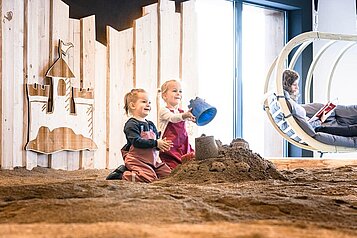 Zwei Mädchen spielen in der Indoor Sandkiste des Familienhotels Allgäuer Berghof.