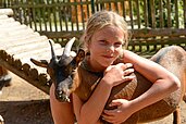 Mädchen streichelt eine Ziege im Kleintiergehege des Familienhotels Family Club Harz. Im Rahmen der Kinderbetreuung werden die lieben Tiere regelmäßig besucht.