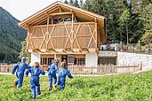 Kinder toben in der Wiese auf dem Gelände des Familienhotels Huber in Südtirol