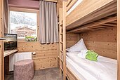 Kinderzimmer mit einem Hochbett und einem Fenster im Familienhotel Galtenberg Family & Wellness Resort in Tirol.