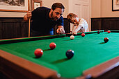 Vater und Sohn spielen zu zweit Billard im Familienhotel Landhaus Averbeck in der Lüneburger Heide.