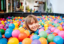 Kind spielt fröhlich im bunten Bällebad des Familien Resort Petschnighof in Kärnten.