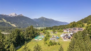 Weitläufige Hotelanlage des Familienhotels Ramsi mit Spielplatz, Sportbereich und herrlichem Bergpanorama in Kärnten.