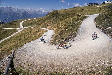 Kinder fahren mit den Mountaincarts die Berge hinunter.