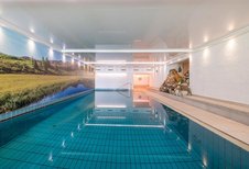 Indoor Schwimmbad mit heller Beleuchtung im Familienhotel Kirchheimerhof in Kärnten.