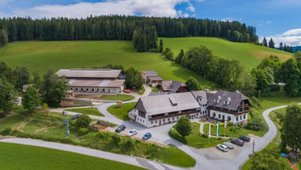 Außenansicht des Familienhotels Der Ponyhof in der Steiermark. Das Hotel ist umgeben von einem großzügigen Außenbereich mit viel Platz für die Kinder zum Spielen.