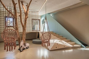 Kinderspielbereich mit Schaukeln und Klettermöglichkeiten im Familienhotel Engel Gourmet & Spa