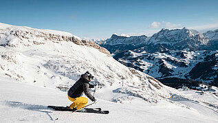 Ein Skifahrer bei der Abfahrt. Die Berge in Südtirol eignen sich für den perfekten Familienurlaub im Winter.