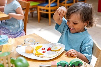 Junge isst ein Kindergericht im Restaurant des Familienhotels Family Club Harz