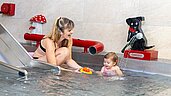 Mutter spielt mit Ihrer Tochter im Kinderschwimmbecken des Familienhotels Feldberger Hof im Schwarzwald.