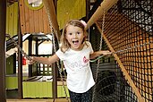 Lachendes Mädchen im Indoor-Spielland des Familienhotels Landhaus zur Ohe im Bayerischen Wald.