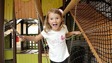 Lachendes Mädchen im Indoor-Spielland des Familienhotels Landhaus zur Ohe im Bayerischen Wald.