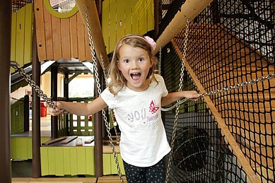 Lachendes Mädchen im Indoor-Spielland des Familienhotels Landhaus zur Ohe im Bayerischen Wald.