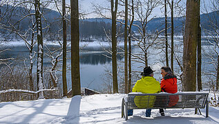 Gemütlich die Sonne genießen bei einer kurzen Pause am See im Sauerland. Ein toller Ausflug am Wald im Sauerland.