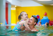 Vater und Tochter verbringen gemeinsam etwas Zeit im Schwimmbad vom Familienhotel Kolping Hotel Spa & Family Resort in Ungarn.