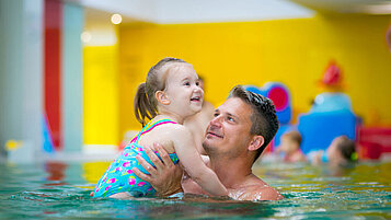 Vater und Tochter verbringen gemeinsam etwas Zeit im Schwimmbad vom Familienhotel Kolping Hotel Spa & Family Resort in Ungarn.