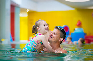 Vater und Tochter verbringen gemeinsam etwas Zeit im Schwimmbad vom Familienhotel Kolping Hotel Spa & Family Resort in Ungarn.