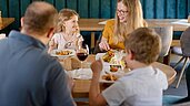 Eine Familie mit Kindern beim gemeinsamen Abendessen im Familienhotel Ottonenhof im Sauerland.