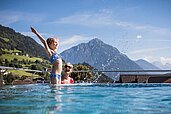 Mutter und Tochter planschen im beheizten Panorama-Outdoor-Pool des Kinderhotels Stefan in Österreich.