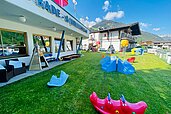 Große Spielwiese mit Kletterstein, Tracktoren und Fußballtor im Wellness- & Familienhotel Egger in Saalbach Hinterglemm.