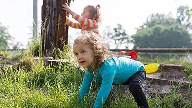 Kleines Mädchen spielt in der Wiese des Landhuus Laurenz.