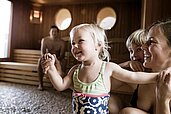 Eltern mit ihren beiden Kinder in der Familiensauna des Familienhotels Allgäuer Berghof.