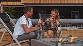 Eltern lassen den Abend bei einem Drink auf der Terrasse des Familienhotels Huber in Südtirol ausklingen.
