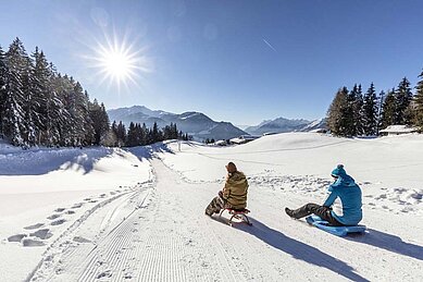 Kinder Rodeln auf Rodelpiste des Familienhotels Galtenberg Family & Wellness Resort in Tirol. 