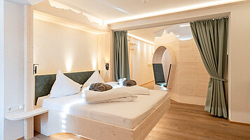Doppelbett in einer 2 Raum-Suite mit einem Balkom im Familienhotel Hotel Tirolerhof an der Zugspitze.