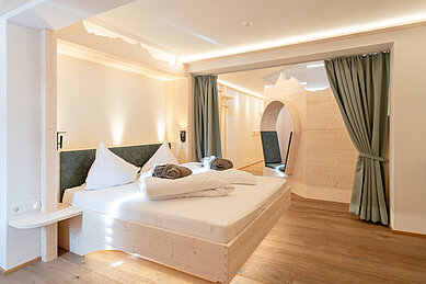 Doppelbett in einer 2 Raum-Suite mit einem Balkom im Familienhotel Hotel Tirolerhof an der Zugspitze.