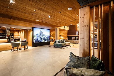 Große helle Lobby mit einem Kamin im Familienhotel Das Bayrischzell in Oberbayern.