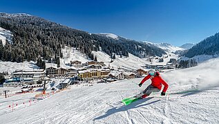 Ein Skifahrer auf der Skipiste oberhalb des Familienhotels Zauchenseehof im Salzburger Land 