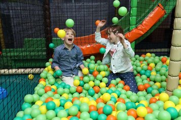 Zwei Kinder toben im Bällebad im Happy-Club des Familienhotels Feldberger Hof.