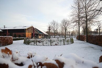 Spielplatz des Familienhotels Landhuus Laurenz im verschneiten Winter.