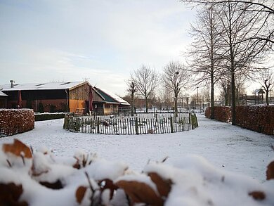 Spielplatz des Familienhotels Landhuus Laurenz im verschneiten Winter.