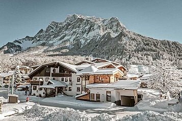 Das Familienhotel Tirolerhof in der Tiroler Zugspitzarena umgeben von einer weißen Winterlandschaft.