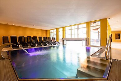 Indoor Therme mit Ambientebeleuchtung und Liegen zum Entspannen im Familienhotel Galtenberg Family & Wellness Resort in Tirol.