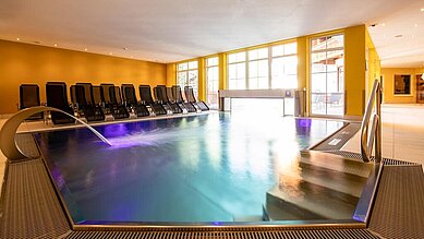 Indoor Therme mit Ambientebeleuchtung und Liegen zum Entspannen im Familienhotel Galtenberg Family & Wellness Resort in Tirol.