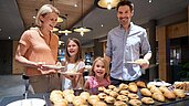 Familie bedient sich am Frühstücksbuffet des Familienhotels Schreinerhof im Bayerischen Wald.