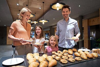 Familie bedient sich am Frühstücksbuffet des Familienhotels Schreinerhof im Bayerischen Wald.