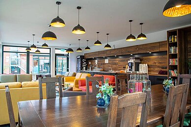 Lounge in der Cafeteria mit Sitzmöglichkeiten und Panoramafenster im Familienhotel Gut Landegge im Emsland.